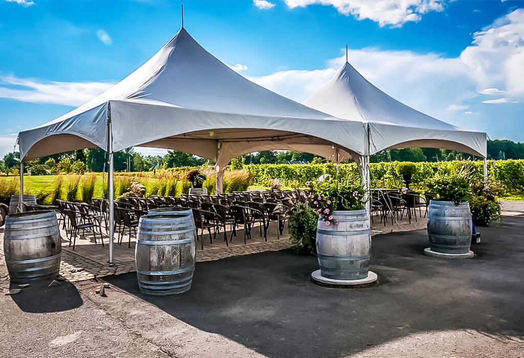 Elegant outdoor tent setup with chairs and decorative barrels, ideal for events and celebrations in Chicago.